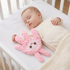 Baby Sleep Aid Patting Hand in pink bunny design, resting on a sleeping baby in a cot