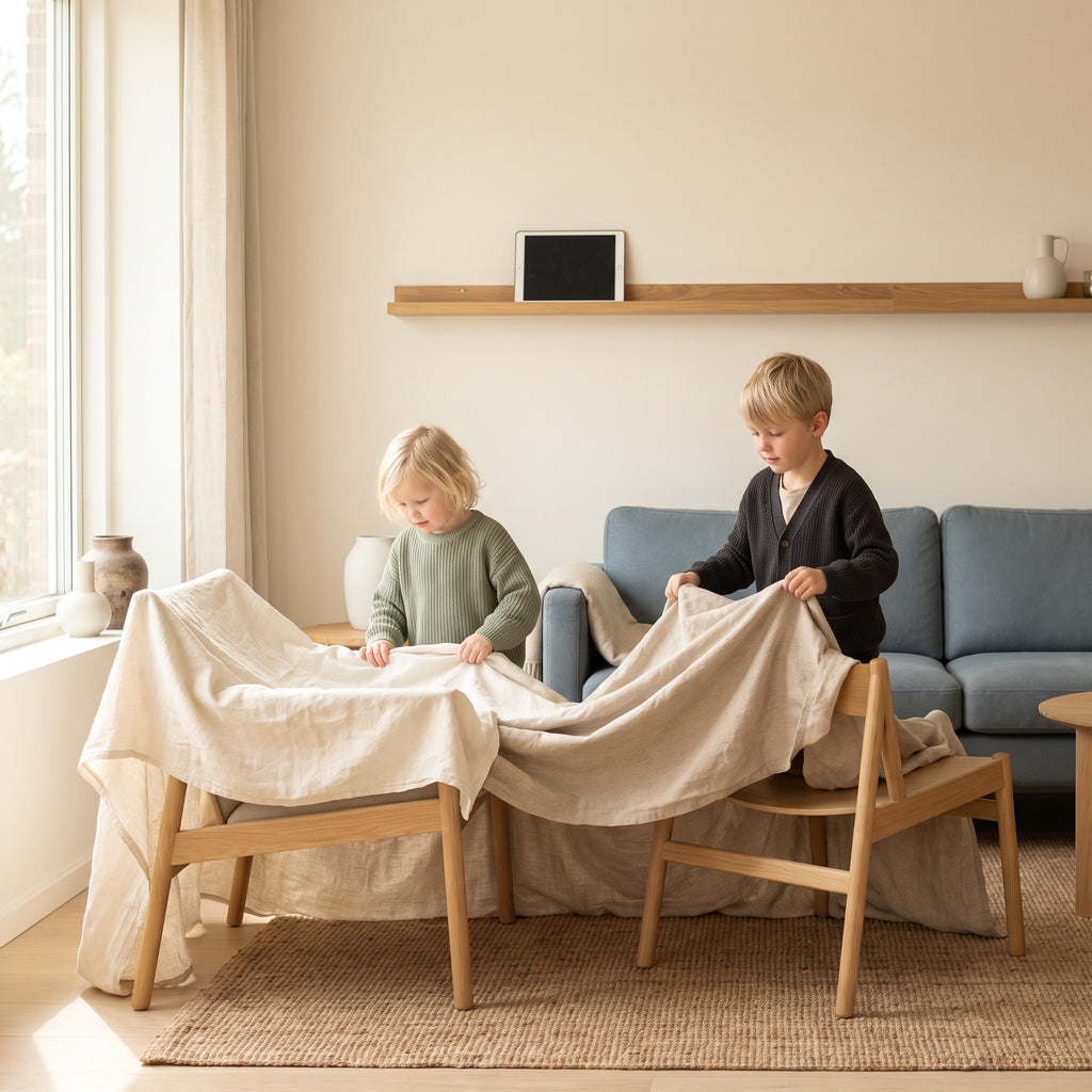 Two children building a blanket fort with the tablet put away
